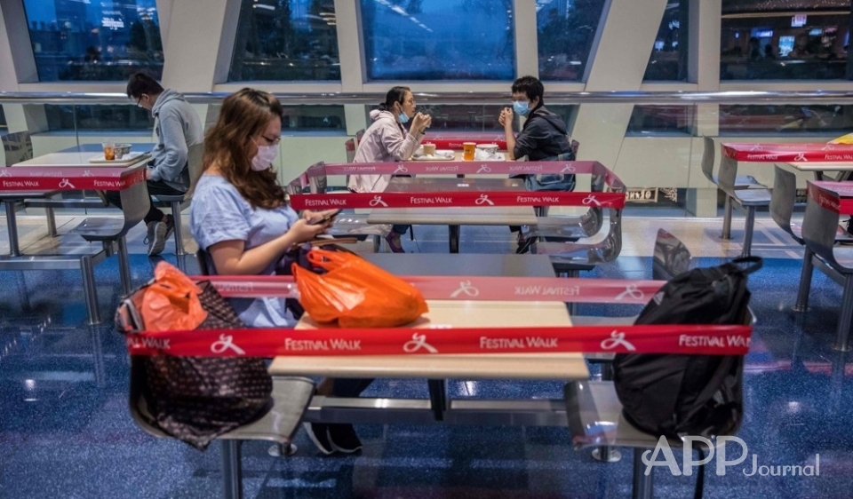 신종 코로나바이러스 감염증(코로나19) 차단을 위한 '사회적 거리 두기' 일환으로 테이블과 의자 주변에 빨간 테이프가 둘린 홍콩의 한 쇼핑몰 안 푸드코트에서 4월4일(현지시간) 손님들이 앉아 있다